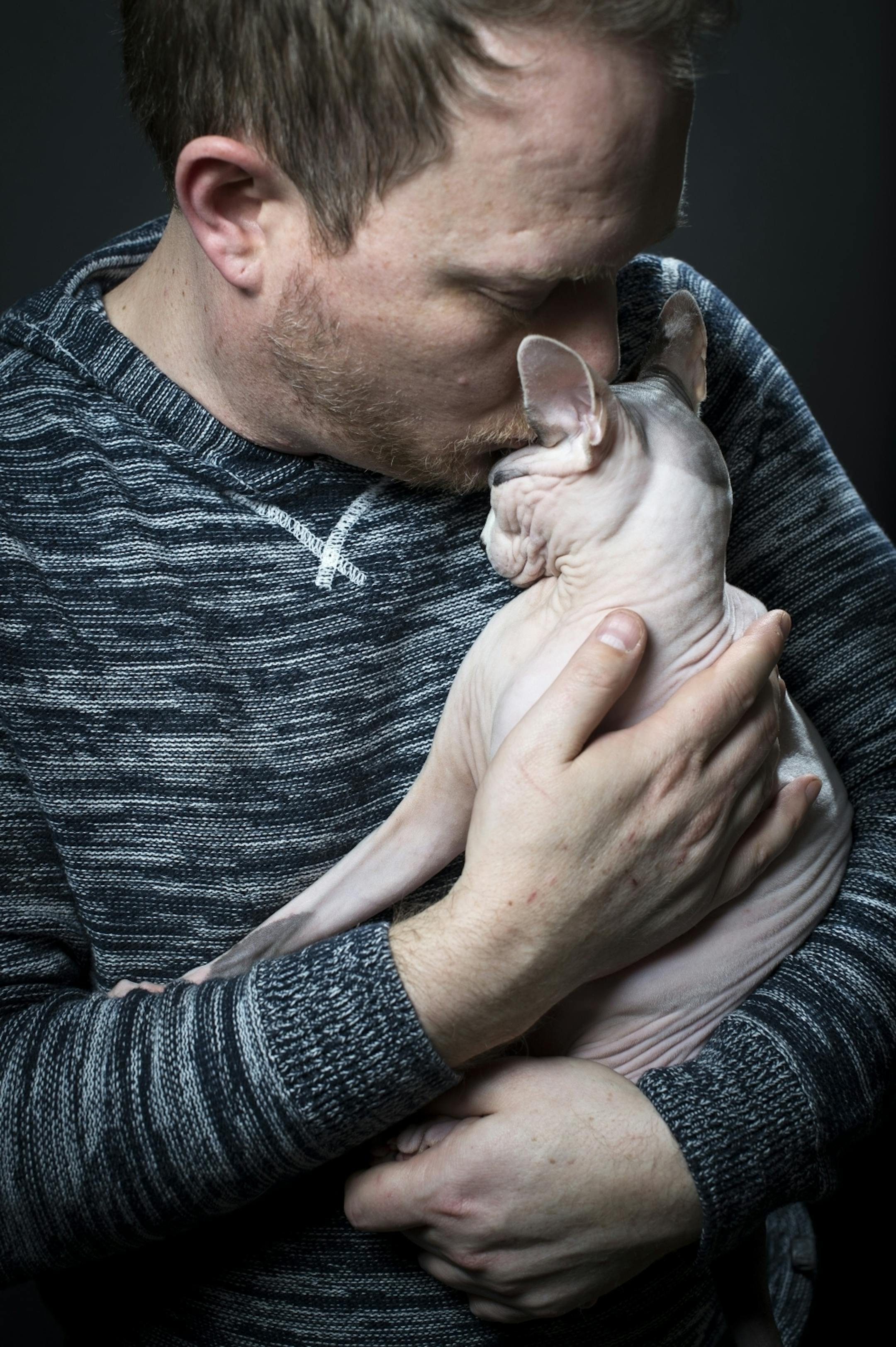 Brian Tripp kisses his Sphynx "Sigur" on Thursday night.