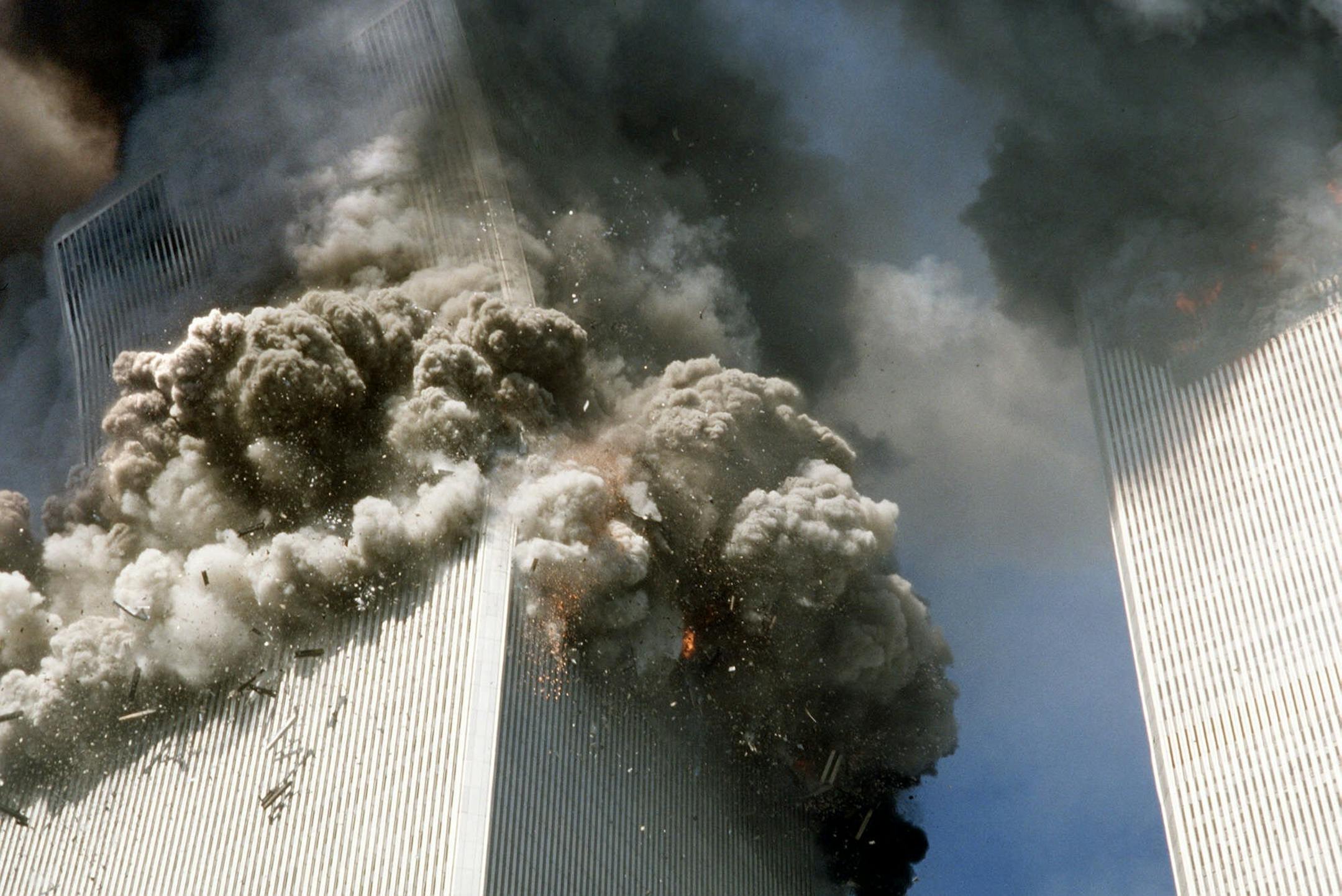 The south tower of the World Trade Center, left, begins to collapse after a terrorist attack on the landmark buildings in New York, Tuesday, Sept. 11, 2001.