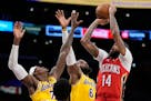 New Orleans Pelicans forward Brandon Ingram, right, shoots as Los Angeles Lakers forward Jarred Vanderbilt, left, and forward LeBron James defend duri