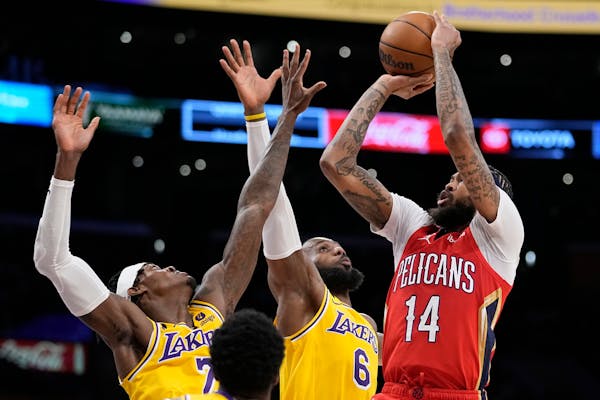 New Orleans Pelicans forward Brandon Ingram, right, shoots as Los Angeles Lakers forward Jarred Vanderbilt, left, and forward LeBron James defend duri