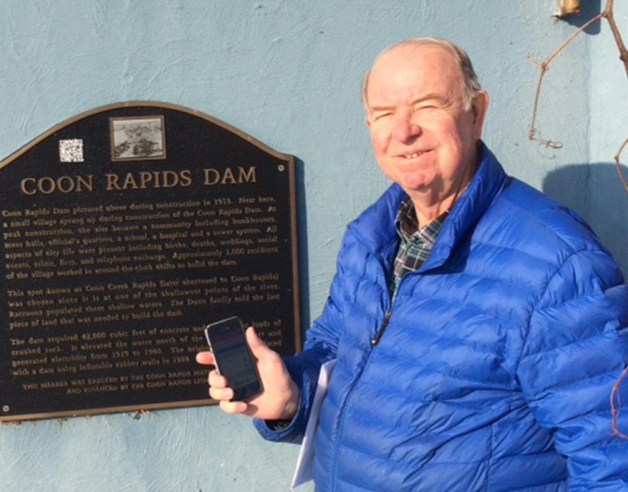 Bob Powell, member of the Coon Rapids Historical Commission shows off one of the existing bronze historical markers at the Coon Rapids Dam. The commission will erect 20 news historical signs this year to share stories the suburbís past. To stretch dollars, the new signs will be made of more modern materials. The goal is also to continue the cityís QR code project, which allows visitors to scan the sign with their smartphones and access a short historical video. The Coon Rapids Communit