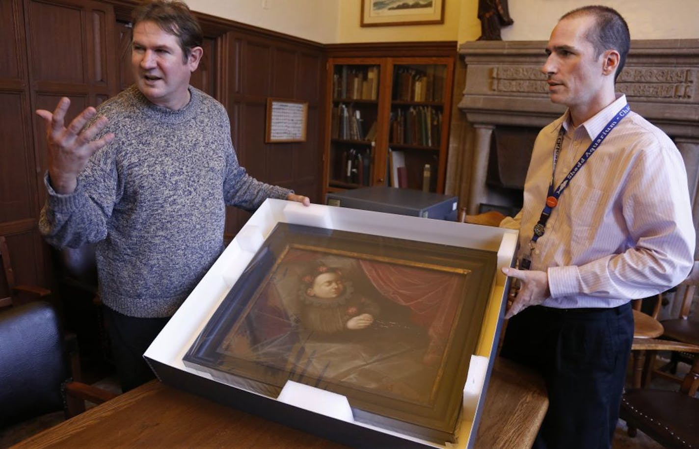 In this Oct. 29, 2013, photo taken in Evanston, Ill., Scott Krafft, left, curator of the Charles Deering McCormick Library of Special Collections, and manuscript librarian Benn Joseph display a painting of a dead Spanish boy from the 1600s.