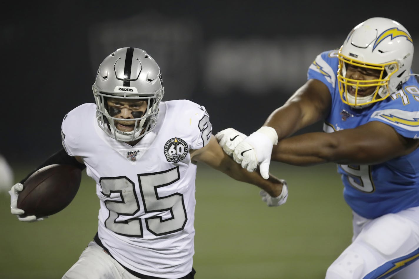 Oakland Raiders free safety Erik Harris (25) runs past Los Angeles Chargers offensive tackle Trey Pipkins to return an interception for a touchdown during the first half of an NFL football game in Oakland, Calif., Thursday, Nov. 7, 2019. (AP Photo/Ben Margot)