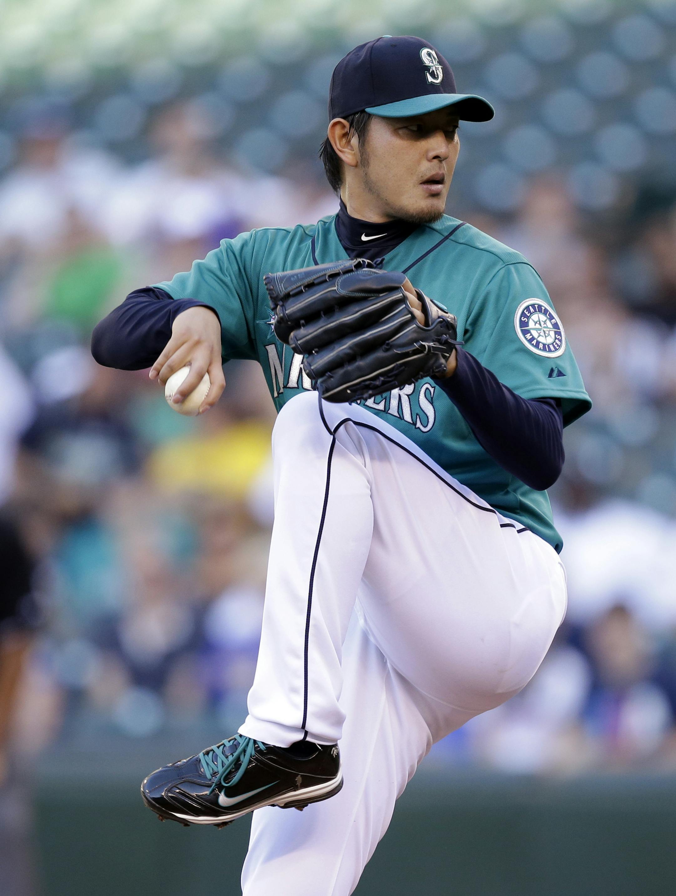 Seattle Mariners starting pitcher Hisashi Iwakuma throws against the Minnesota Twins in the first inning of a baseball game Monday, July 7, 2014, in Seattle. (AP Photo/Elaine Thompson)