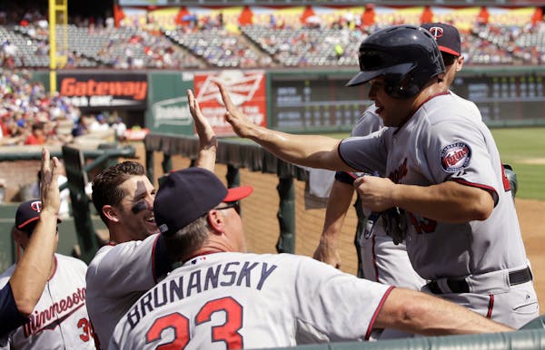 Minnesota Twins' Josmil Pinto, right, is congratulated in the dugout after scoring on a Doug Bernier ground rule double in th fifth inning of a baseba