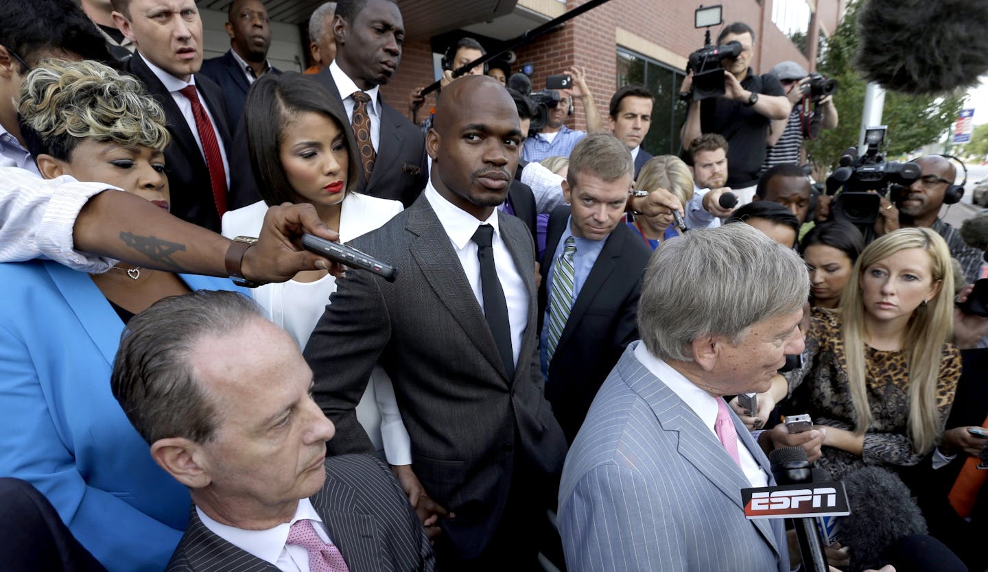 Vikings running back Adrian Peterson, center, stands with his wife Ashley Brown Peterson, center left, and mother Bonita Jackson, far left, as they listen to Peterson's attorney Rusty Hardin, right, outside a Texas courthouse Wednesday.