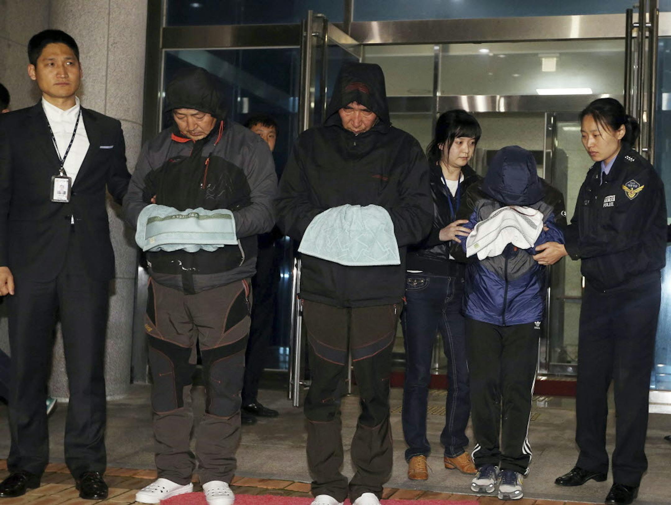 Lee Joon-seok, third from left, the captain of the ferry Sewol that sank off South Korea, and two crew members prepare to leave a court which issued their arrest warrant in Mokpo, south of Seoul, South Korea.