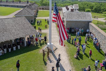 The flag is raised at Historic Fort Snelling during Memorial Day services on Monday.