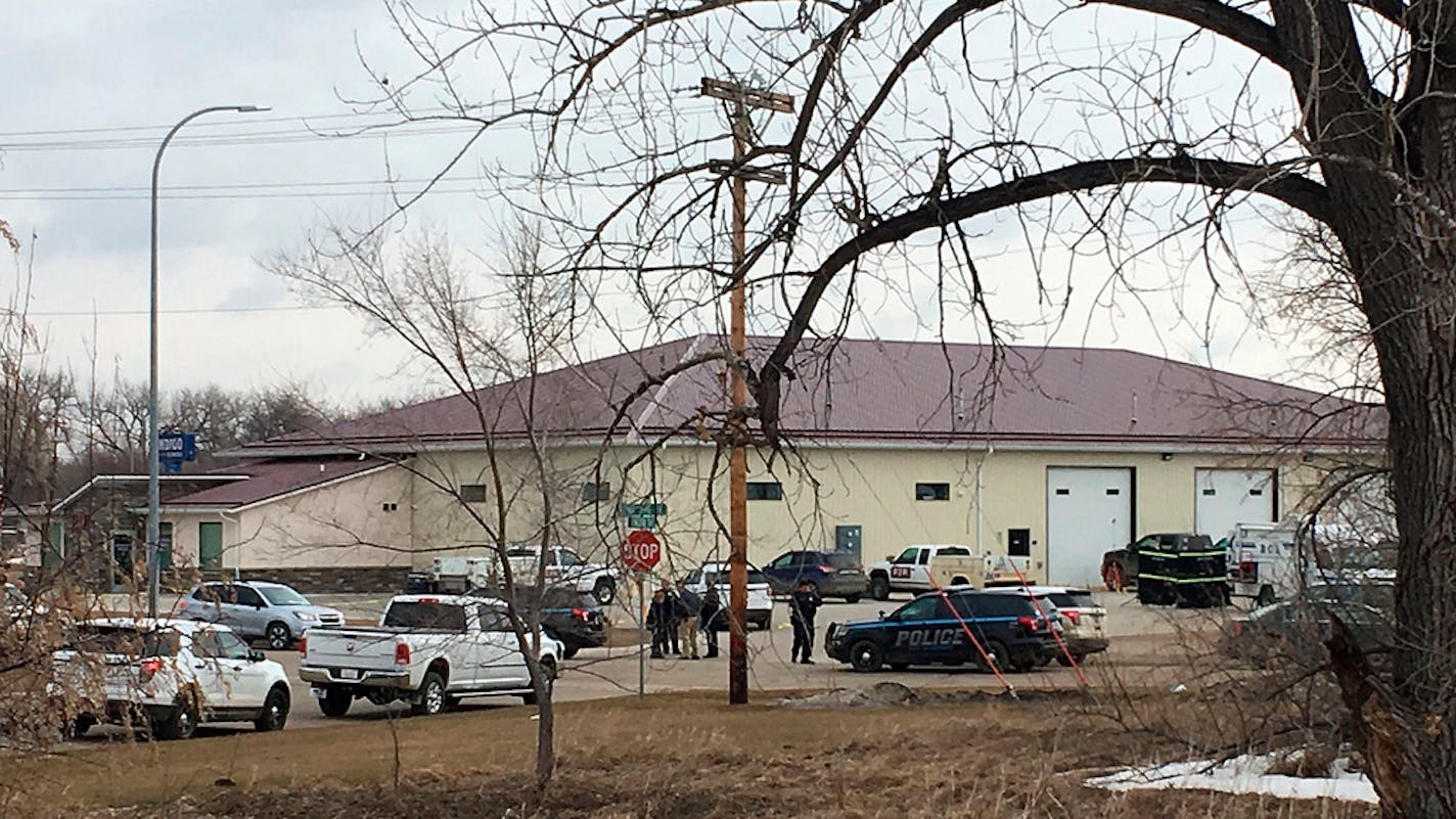 Police vehicles are seen in the backside of RJR Maintenance and Management, a property management company, Monday, April 1, 2019, Mandan, N.D. Authorities say police responding to a medical call at the North Dakota business have found "several" bodies. The Mandan Police Department issued a three-sentence news release confirming that officers had found "several people who were deceased inside" the business in the city of about 22,000 just across the Missouri River west of Bismarck. (AP Photo/Blak