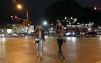 Two women cross a street in an entertainment district Thursday, Nov. 19, 2020, in Santa Monica, Calif. California Gov. Gavin Newsom is imposing an ove