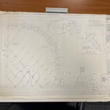 Blueprints sit on a wooden table