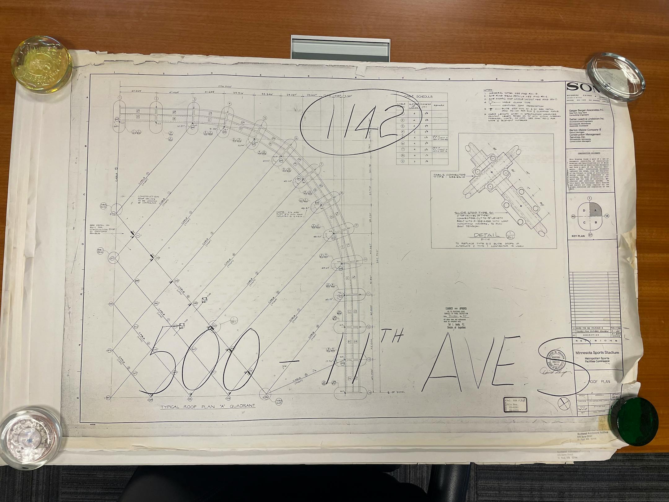 Blueprints sit on a wooden table