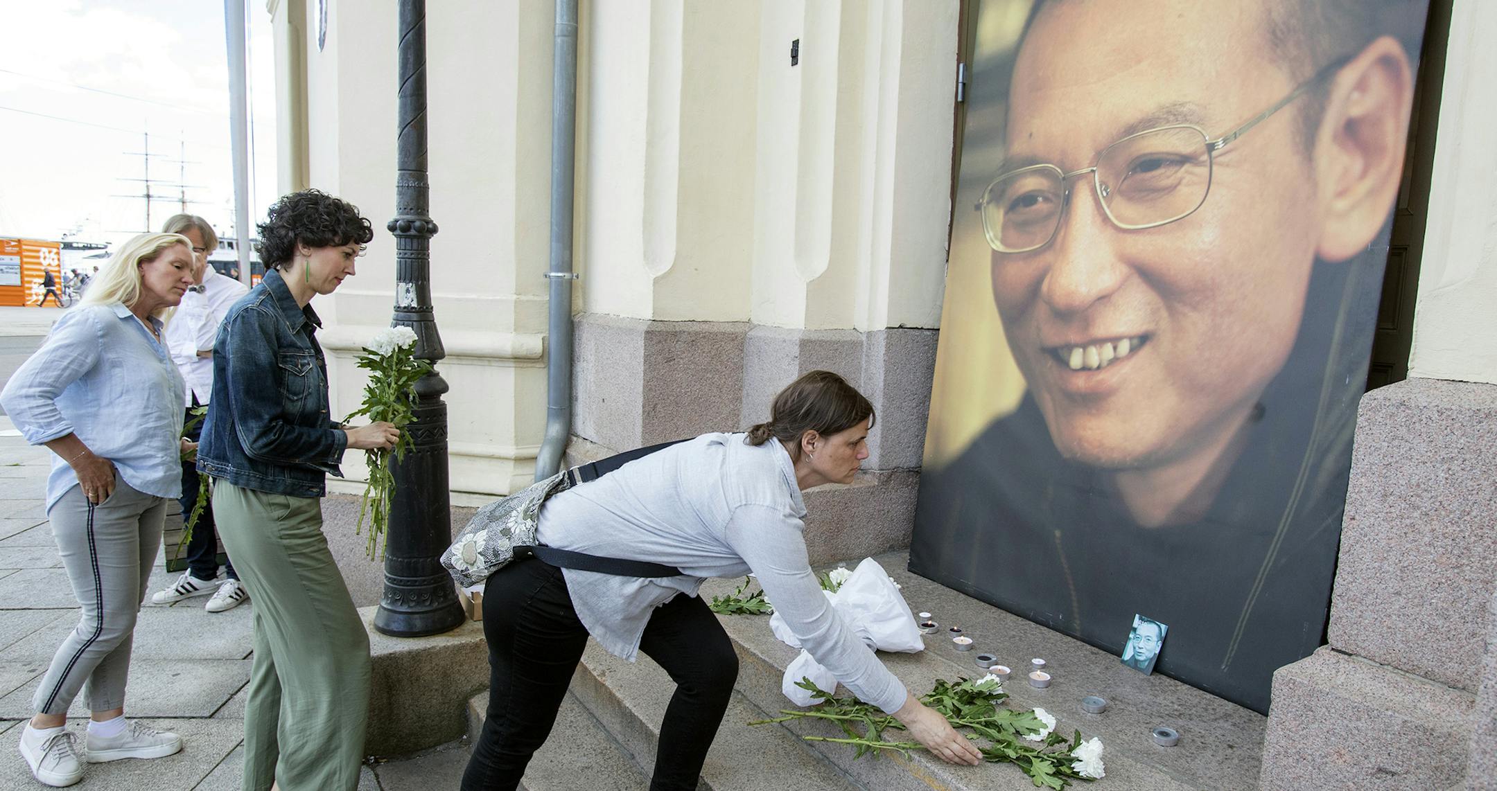 People place flowers and light candles in front of a picture of Liu Xiaobo, placed outside the Nobel's Peace center in Oslo, Thursday, July 13, 2017. Officials say China's most prominent political prisoner, Nobel Peace Prize laureate Liu Xiaobo, has died. He was 61. (Audun Braastad/NTB scanpix via AP) ORG XMIT: MIN2017071416273850