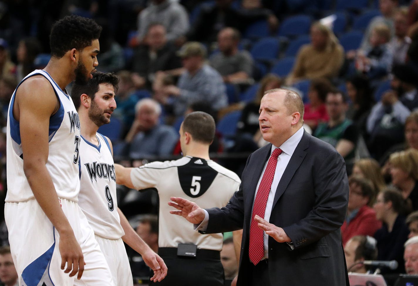 Minnesota Timberwolves head coach Tom Thibodeau talks with Timberwolves center Karl-Anthony Towns (32) and guard Ricky Rubio (9)