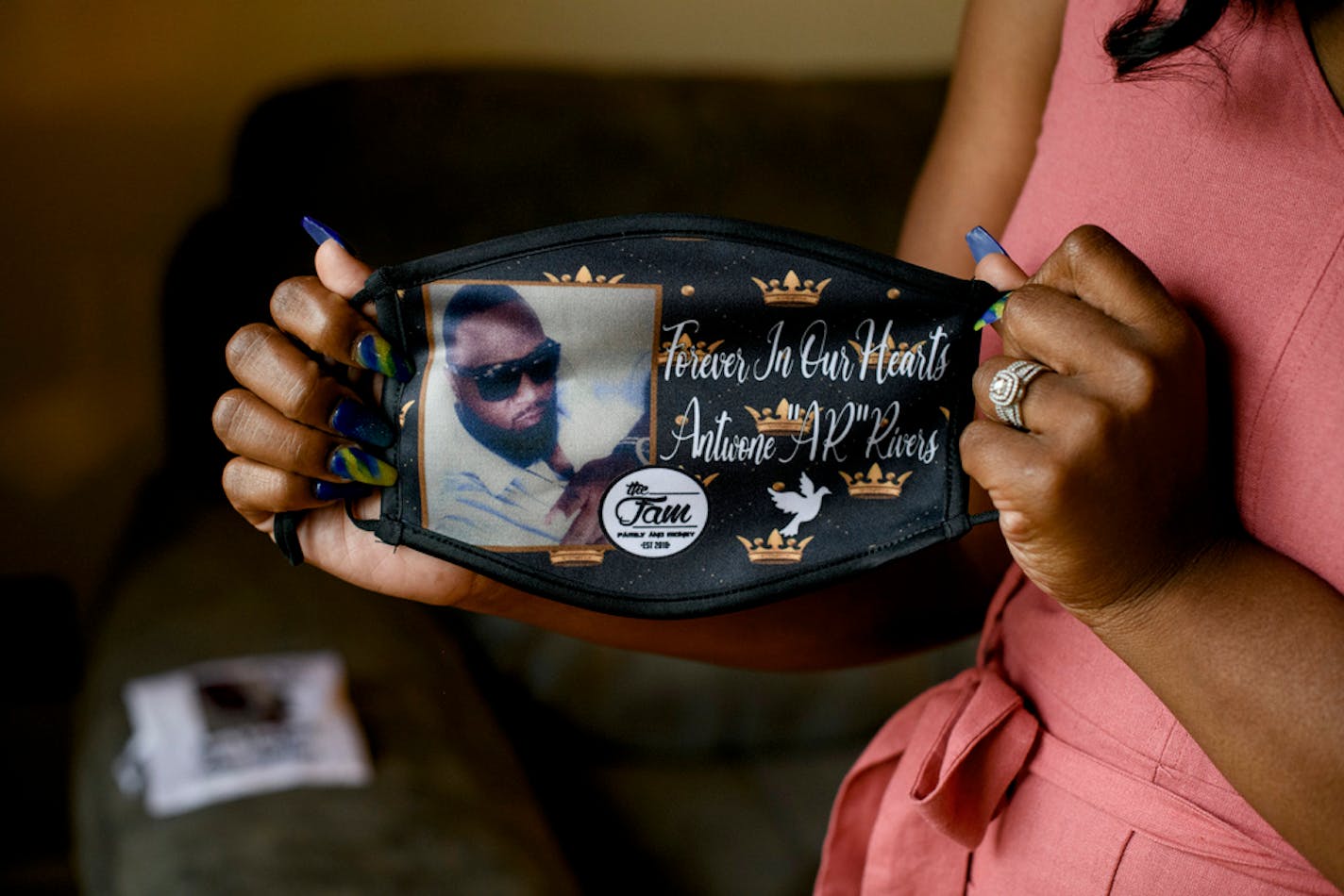 Hollie Rivers shows a mask commemorating her husband Antwone, who died of COVID-19, at her home in Lincoln Park, Mich., May 28, 2021. COVID-19 hospitalizations and deaths in the U.S. are lower than they have been in many months and vaccination rates continue to slowly climb. But there are still about 450 deaths reported each day, and that has left hundreds of families dealing with a new kind of pandemic grief. (Brittany Greeson/The New York Times)