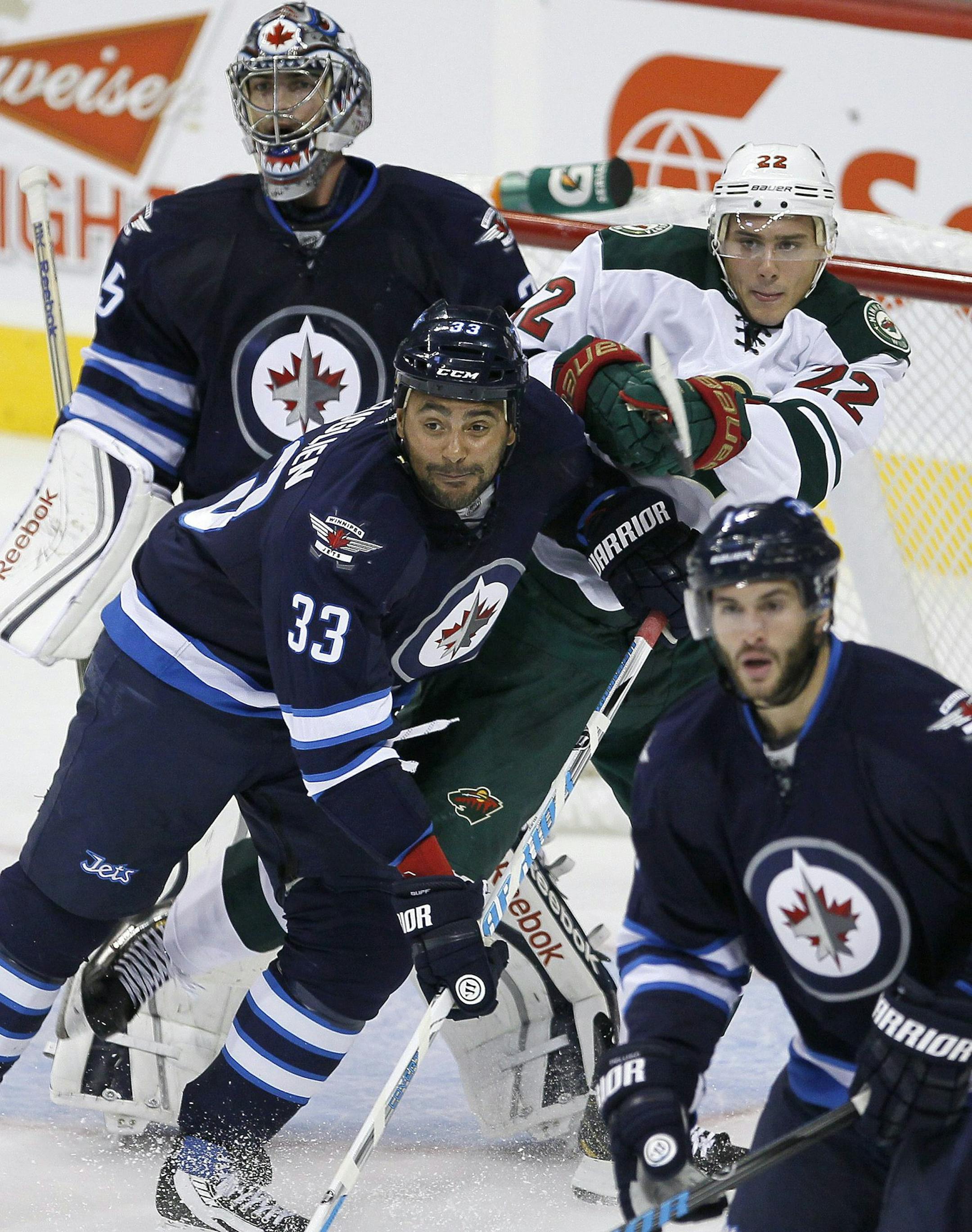 Winnipeg Jets' Dustin Byfuglien (33) and Minnesota Wild's Nino Niederreiter (22) fight for position in front of Jets' goaltender Al Montoya (35) during first-period preseason NHL hockey game action in Winnipeg, Manitoba, Thursday, Sept. 19, 2013. (AP Photo/The Canadian Press, John Woods)