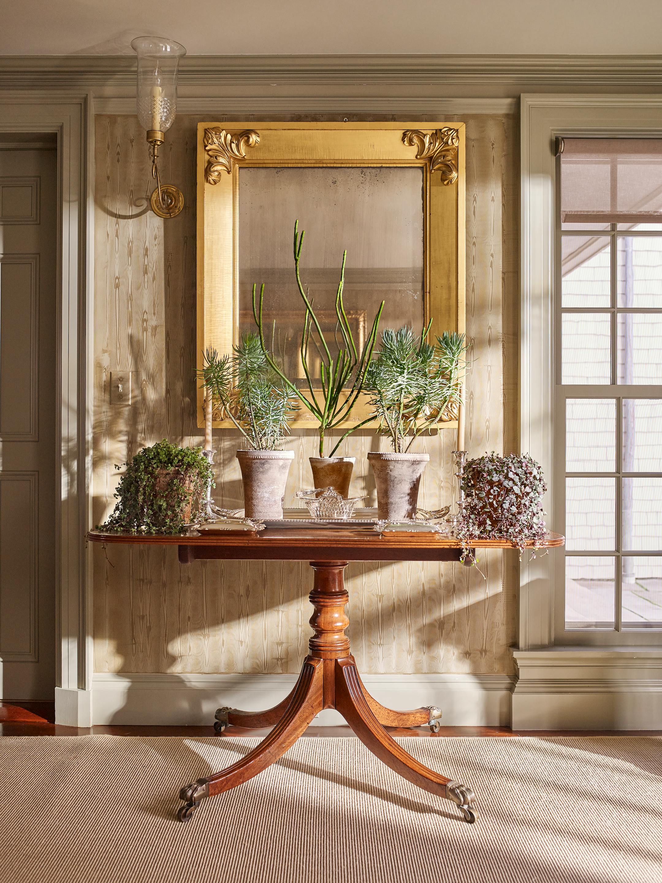 BC-ASK-MARTHA-BEDFORD-INTERIORS-ART-NYTSF — Two console tables (actually halves of an out-of-service dining table) now flank the doorway leading from Martha's new sitting room into the servery and kitchen — another blank spot made beautiful to behold. This one holds a pencil cactus (center) and pairs of senecio and chain of hearts. Mirrors above each half amplify the room's natural light during the day, too. "Putting a mirror on the wall is like adding a window," says Kevin Sharkey. (Pieter Estersohn/Martha Stewart Living Online) — ONLY FOR USE WITH ARTICLE SLUGGED — BC-ASK-MARTHA-BEDFORD-INTERIORS-ART-NYTSF — OTHER USE PROHIBITED.