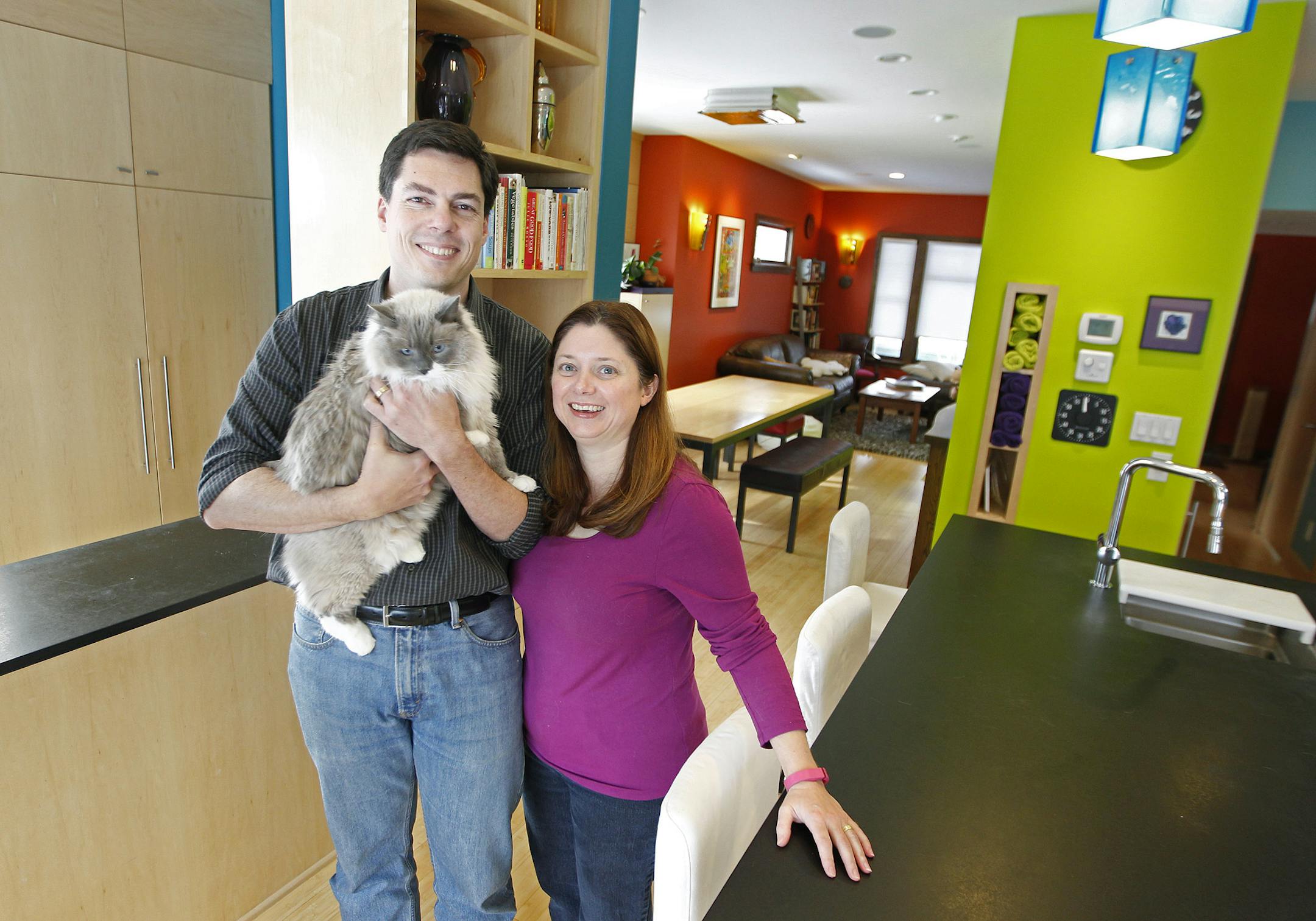Cat-loving couple, Heidi Hardner and Bill Humphrey's remodeled Minneapolis home won the EcoBlend award, for its eco and cat-friendly features. Their architect was Wynne Yelland. Here the couple stood in their kitchen with their cat "Aurora," Friday, January 3, 2014 in Minneapolis, MN. (ELIZABETH FLORES/STAR TRIBUNE) ELIZABETH FLORES • eflores@startribune.com