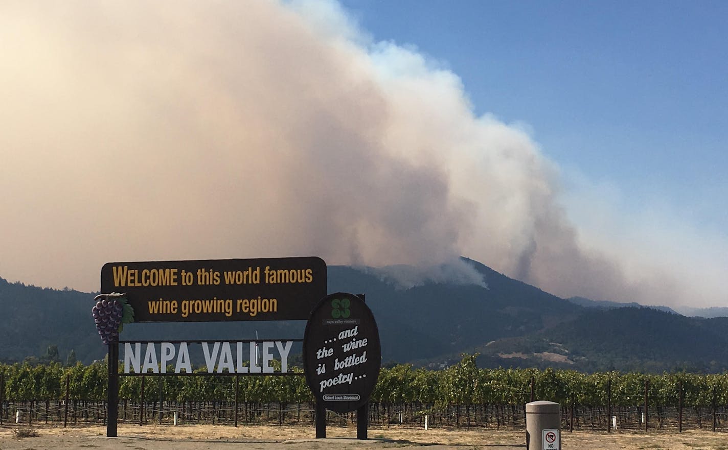 Smoke from the northern California wildfires is seen behind a sign for Napa Valley. Photo by Tom Thornton