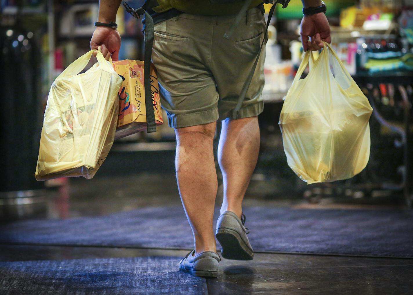 A man carried plastic bags of groceries out of Kowalski's in Uptown in Minneapolis, Minn., on Thursday, July 23, 2015.