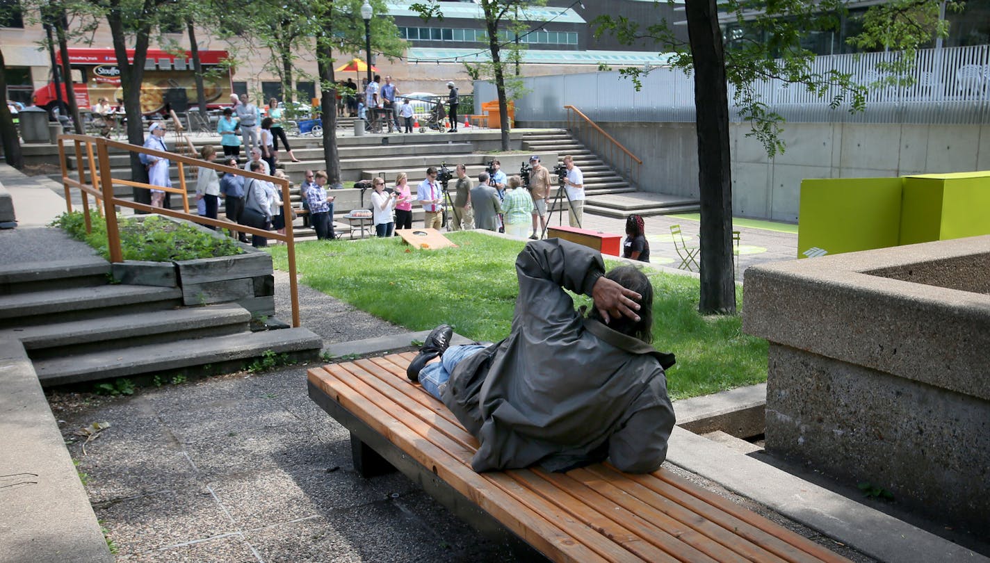 Minneapolis officials and downtown business leaders announced future plans for Peavey Plaza Wednesday, June 10, 2015, in Minneapolis, MN. The plans were vague and did not include funding but organizers said they hoped with a remake the plaza could again become a city square and popular gathering place like it was when the plaza was built in the early 70s. Here, a man who did not wish to give his name took in the press conference from a nearby bench.](DAVID JOLES/STARTRIBUNE)djoles@startribune.co