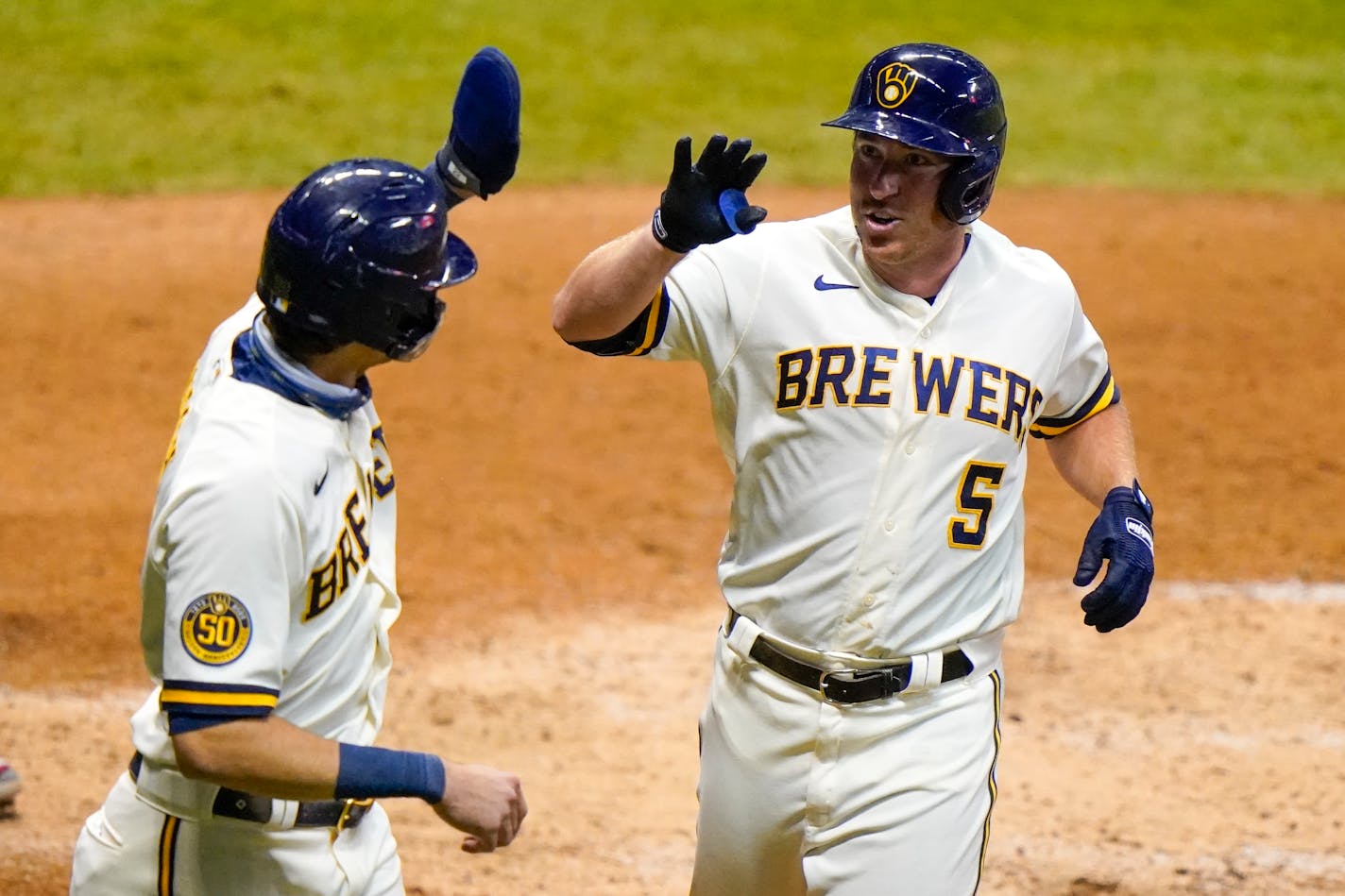 Milwaukee's Jedd Gyorko is congratulated by Christian Yelich after hitting a two-run home run during the eighth inning