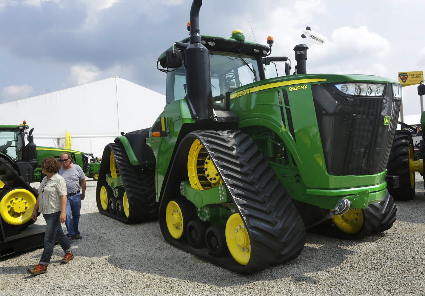 FILE - In this Monday, Aug. 31, 2015, file photo, Douglas and Monika Johnson from Perry, Iowa, look at John Deere equipment on display at the Farm Progress Show in Decatur, Ill. Deere & Co. report financial results Friday, Aug. 19, 2016. (AP Photo/Seth Perlman, File) ORG XMIT: NYBZ501