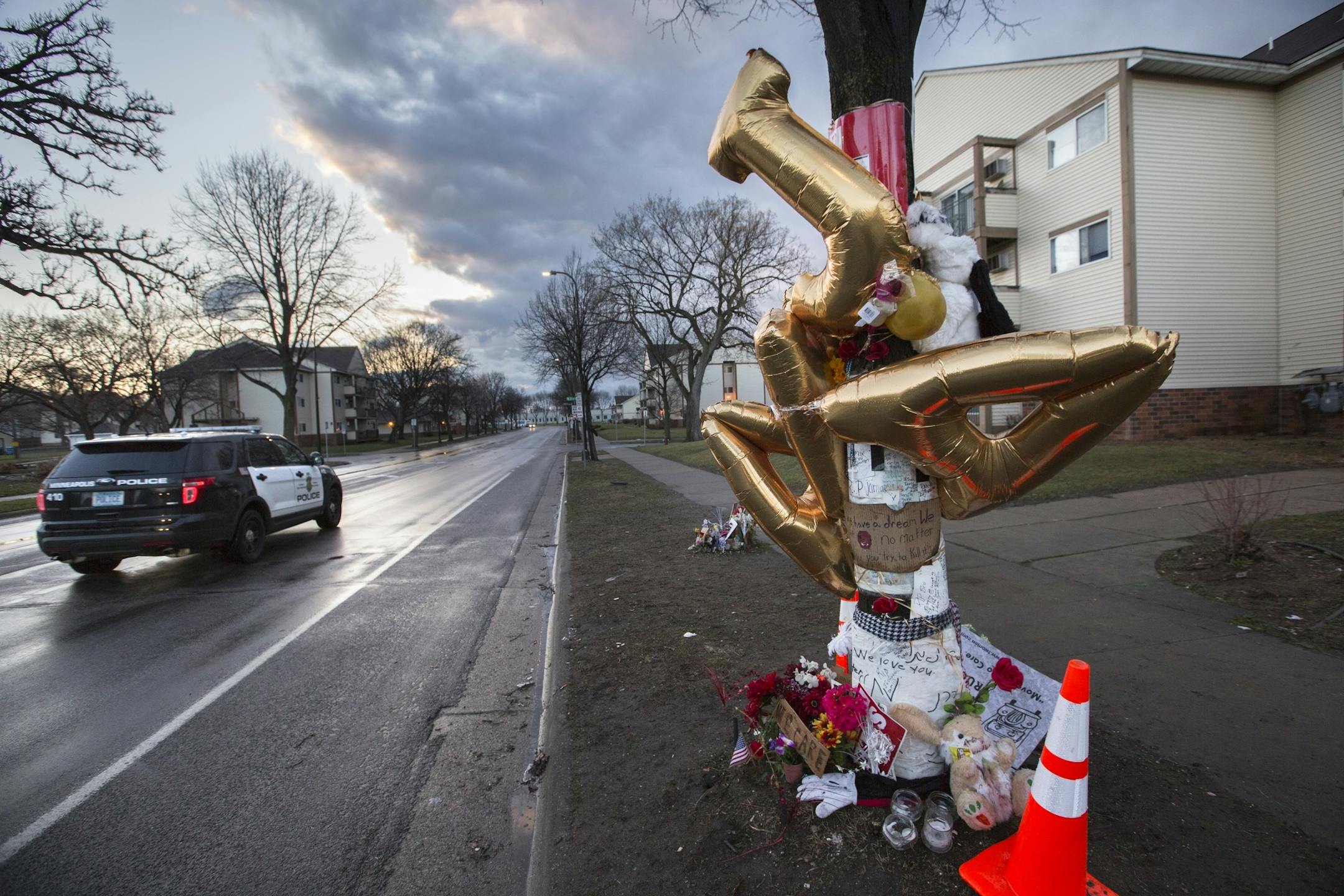 A Minneapolis police car drives by the memorial for Jamar Clark on Plymouth Avenue in the early morning.