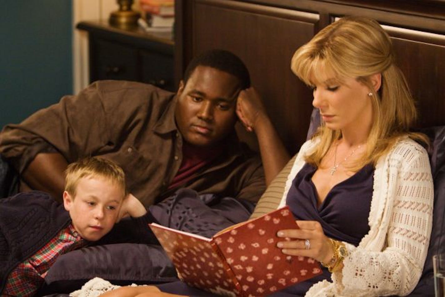 Jae Head as S.J. Tuohy, foreground left, Quinton Aaron as Michael Oher and Sandra Bullock as Leigh Anne Tuohy star in Alcon Entertainment's drama "The Blind Side," a Warner Bros. Pictures release.