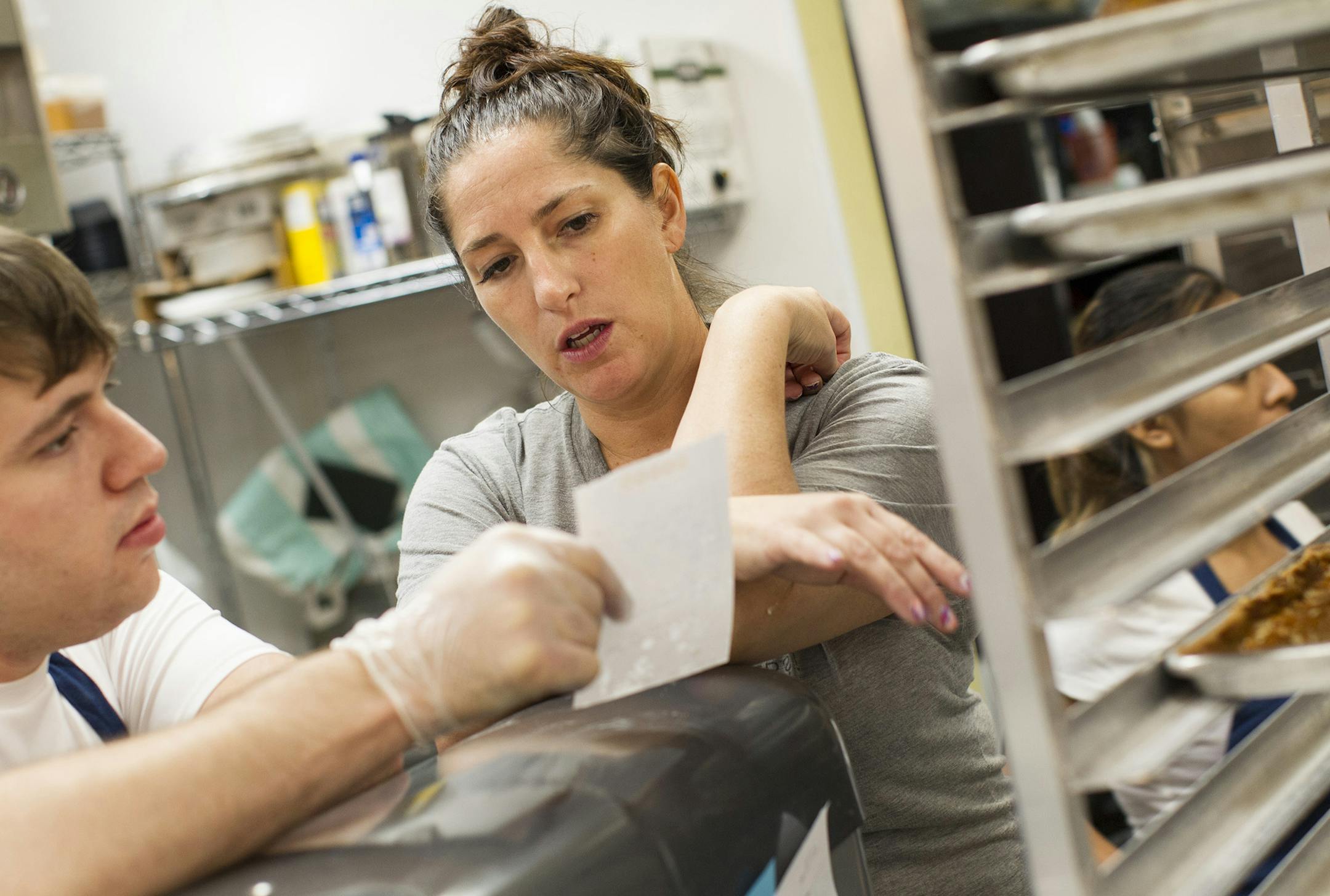 Owner and pastry chef Michelle Gayer, center, advises Tony Lusian on a recipe at Salty Tart in Midtown Global Market in Minneapolis September 21, 2013. (Courtney Perry/Special to the Star Tribune)