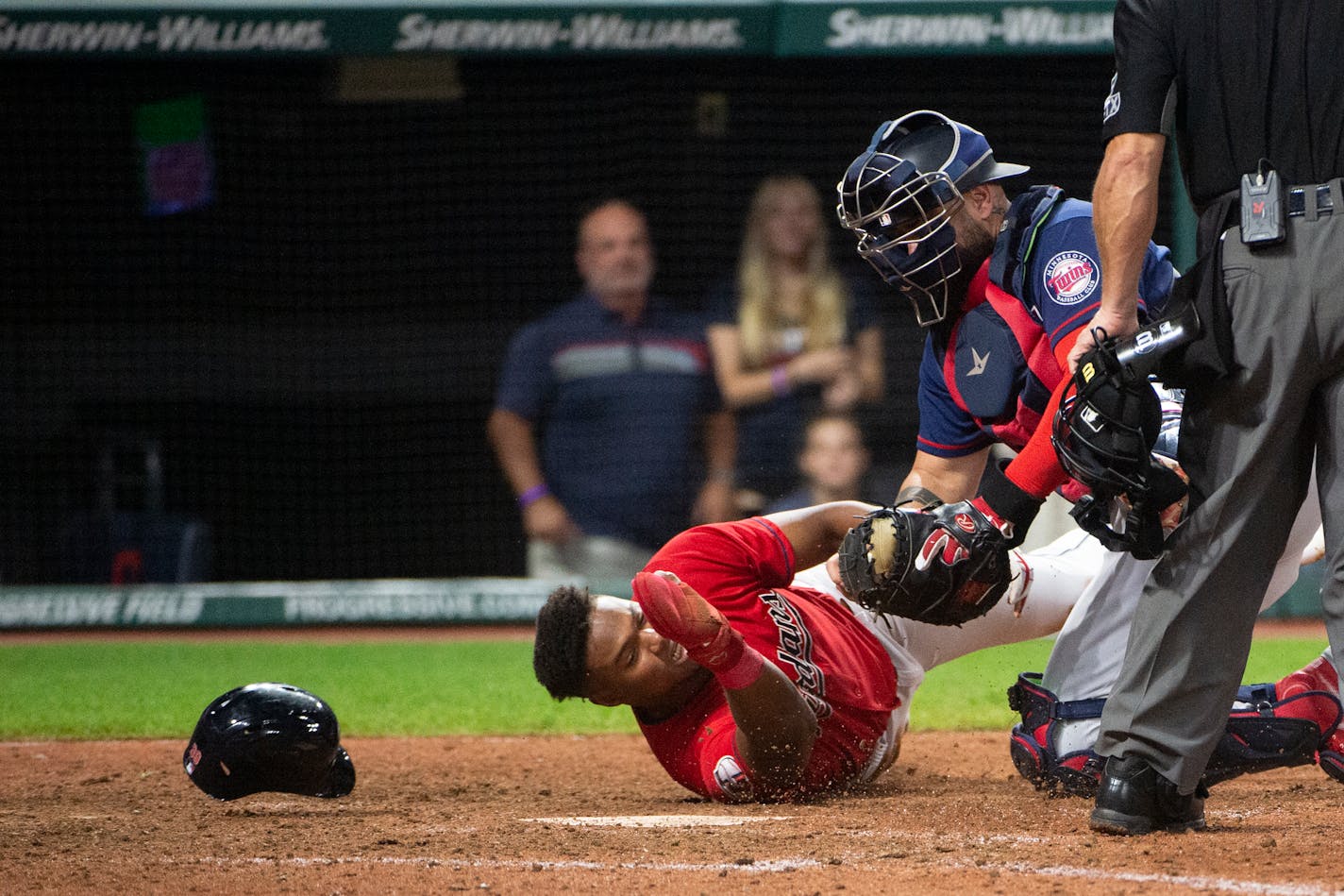 Minnesota Twins' Sandy Leon, second from left, tags out Cleveland Guardians' Oscar Gonzalez, left, at home plate during the 12th inning of the second game of a baseball doubleheader in Cleveland, Saturday, Sept. 17, 2022. (AP Photo/Phil Long)