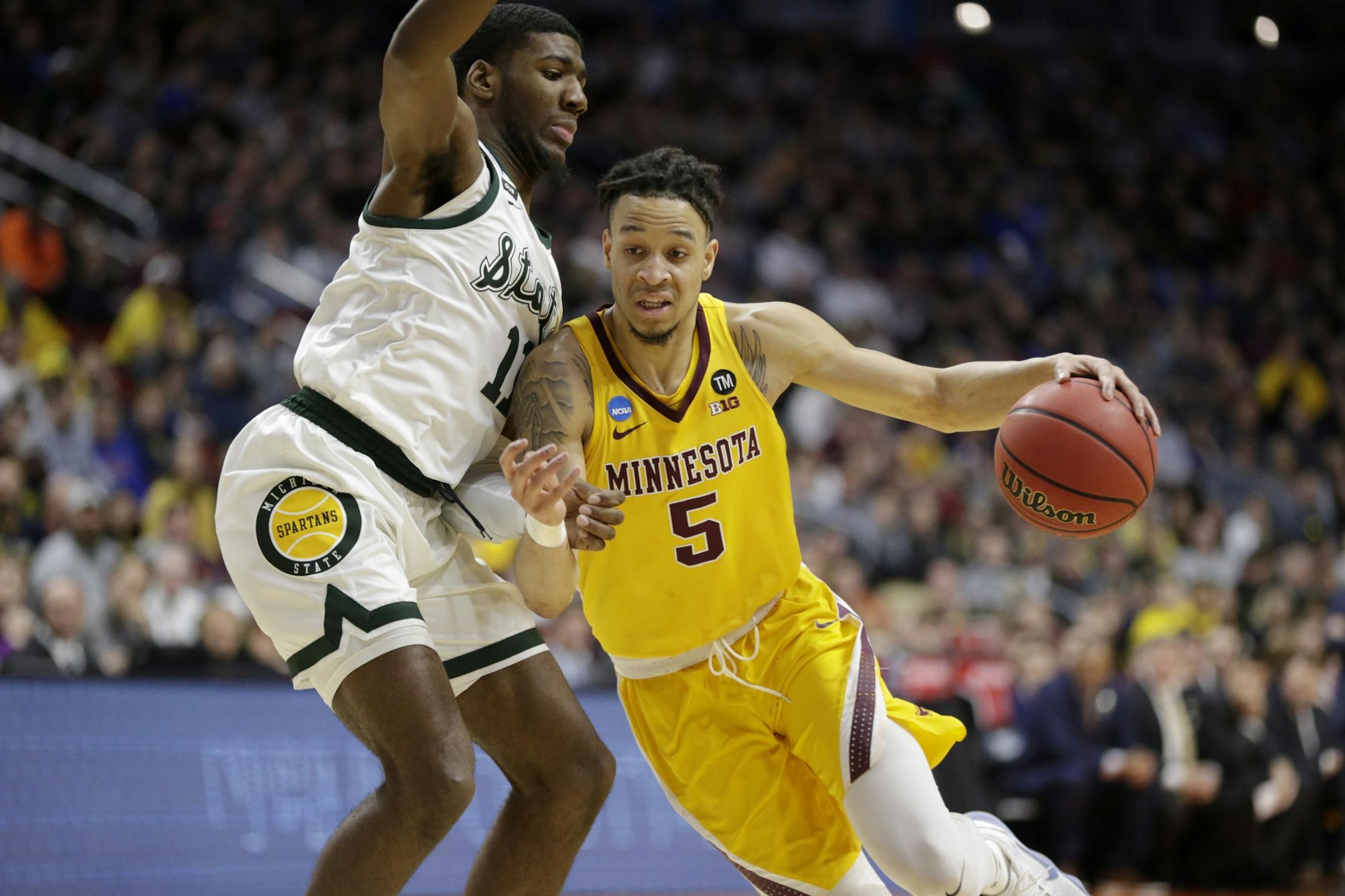 Minnesota's Amir Coffey (5) drives past Michigan State's Aaron Henry (11) during the first half of a second round men's college basketball game in the NCAA Tournament, in Des Moines, Iowa, Saturday, March 23, 2019.