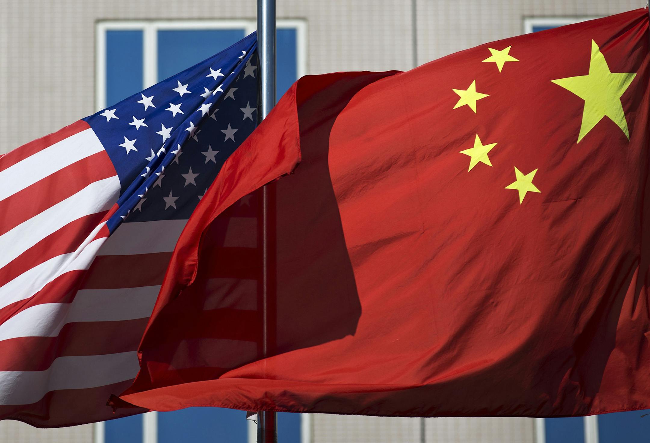 FILE - In this Sept. 5, 2012, file photo, U.S. and China's national flags flutter in winds at a hotel in Beijing. China has denied an accusation by U.S. President Donald Trump that it hacked the emails of Hillary Clinton, his Democratic opponent in the 2016 election. (AP Photo/Andy Wong, File)