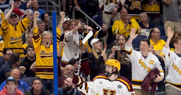 Logan Cooley of Minnesota celebrates in front of a friendly crowd after scoring an empty net goal in the third period.