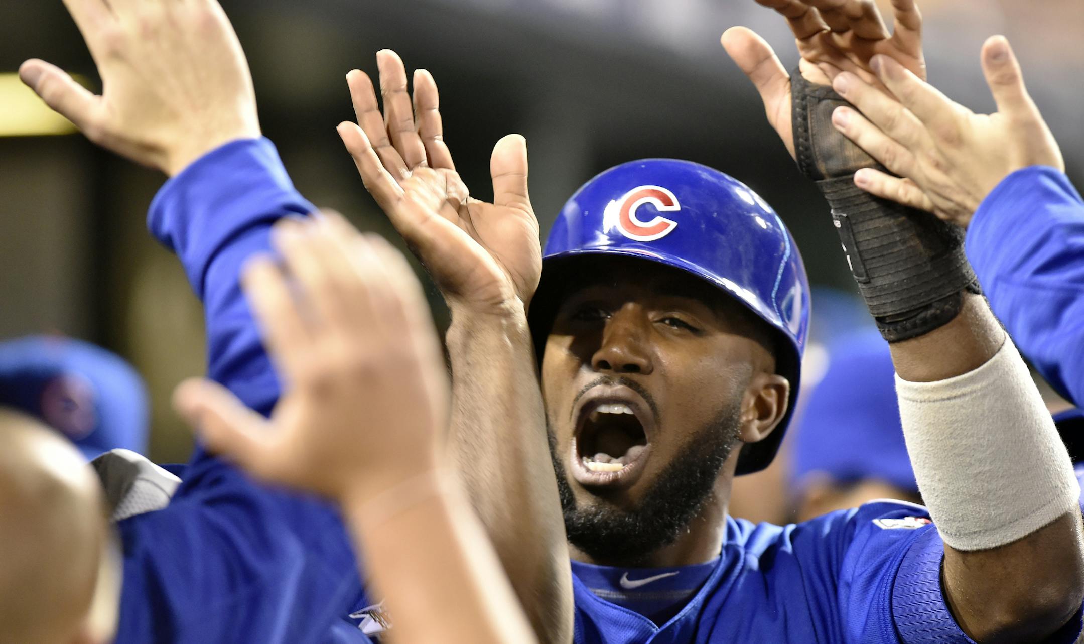 Chicago Cubs' Dexter Fowler celebrates with teammates in the dugout after scoring on a hit by Kyle Schwarber in the first inning of the National League wild card baseball game against the Pittsburgh Pirates, Wednesday, Oct. 7, 2015, in Pittsburgh. (AP Photo/Don Wright)