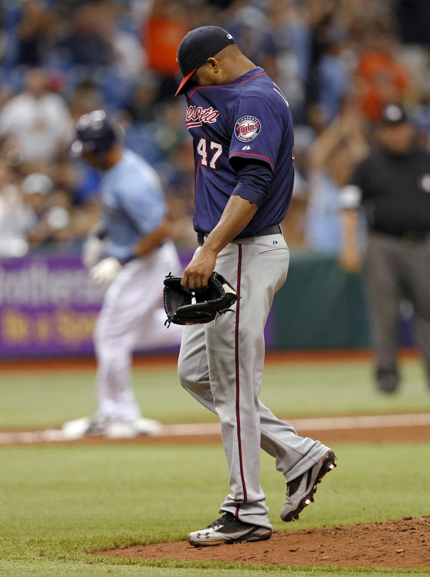 Minnesota Twins starting pitcher Francisco Liriano reacts after giving up a two-run home run to Tampa Bay Rays' Desmond Jennings, rounding the bases in the background, during the fifth inning of a baseball game Sunday, April 22, 2012, in St. Petersburg, Fla.