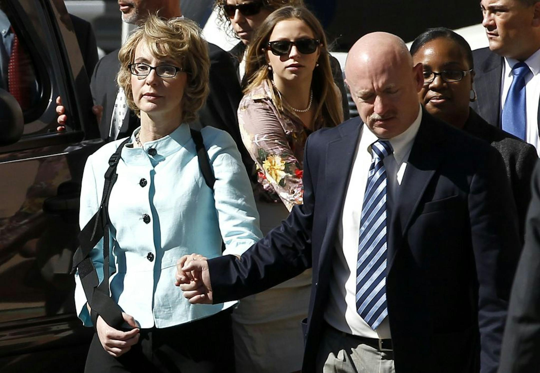 Former Democratic Rep. Gabrielle Giffords, left, and her husband Mark Kelly leave after the sentencing of Jared Loughner, in back of U.S. District Court Thursday, Nov. 8, 2012, in Tucson, Ariz. U.S. District Judge Larry Burns sentenced Jared Lee Loughner, 24, to life in prison, for the January 2011 attack that left six people dead and Giffords and others wounded. Loughner pleaded guilty to federal charges under an agreement that guarantees he will spend the rest of his life in prison without the