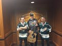 O.A.R. lead singer Marc Roberge and guitarist Richard On, after autographing and drawing a design on Zac Dalpe's guitar, pose with the Wild center aft