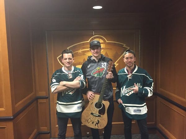 O.A.R. lead singer Marc Roberge and guitarist Richard On, after autographing and drawing a design on Zac Dalpe's guitar, pose with the Wild center aft