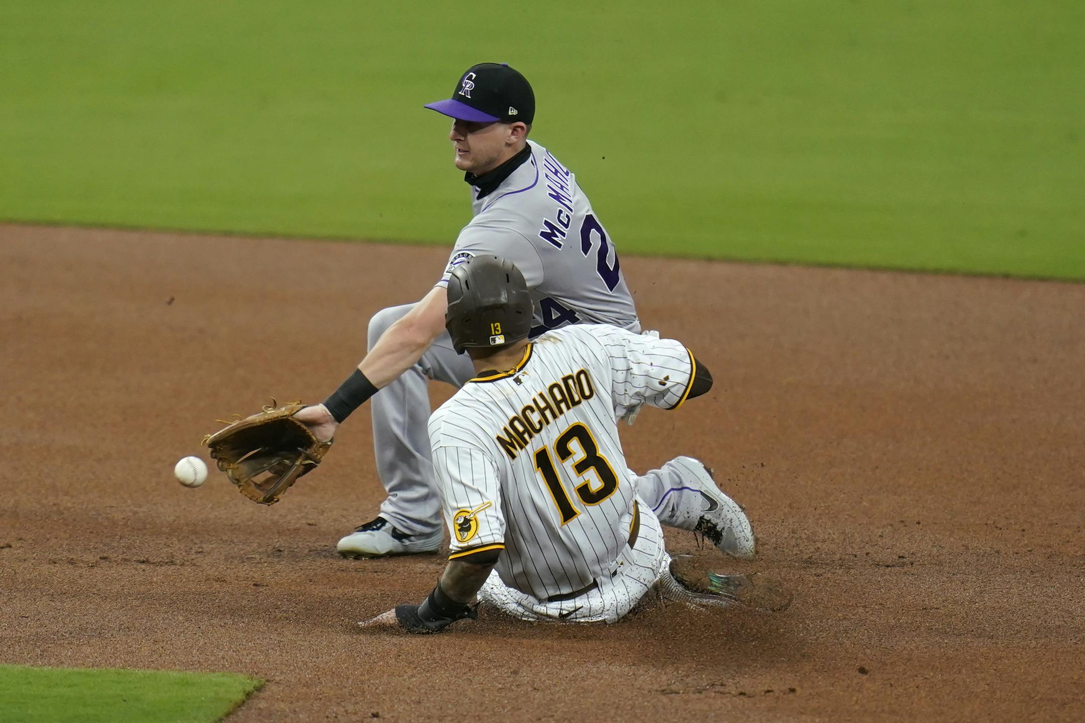Colorado Rockies second baseman Ryan McMahon, top, waits for the throw as San Diego Padres' Manny Machado (13) safely steals second base during the first inning of a baseball game Monday, Sept. 7, 2020, in San Diego. (AP Photo/Gregory Bull)