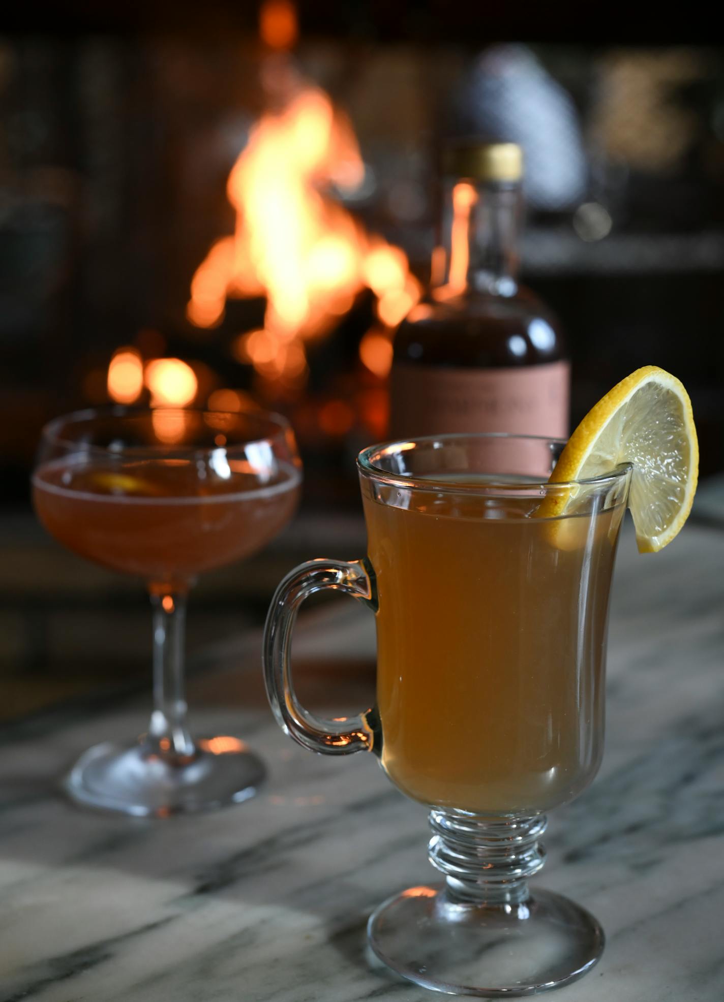 The "Not Hot Toddy" is photographed Friday, Jan. 21, 2022 at WA Frost and Company in St. Paul, Minn. The drink substitutes whiskey with the Gnista Barreled Oak spirit. To the left, the "No Name," the bar's take on the Manhattan cocktail, which substitutes bourbon or rye with Gnista Wormwood and Harmony Smoked Aperitif ] AARON LAVINSKY • aaron.lavinsky@startribune.com