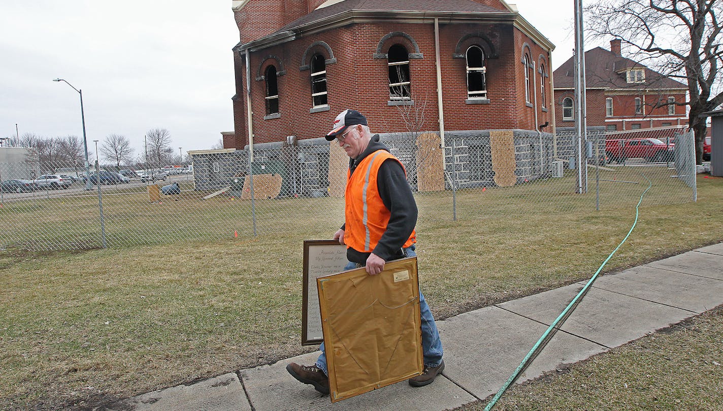 St. Mary's custodian Allan Wiechmann carried some historic frames recovered after Friday&#x2019;s fire.