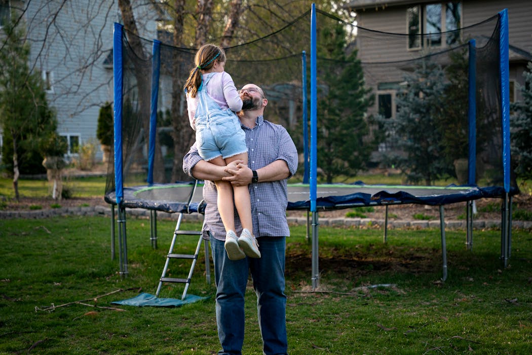 Michael Getman lifts up his daughter Addie, 7, in their Eden Prairie backyard on April 24.