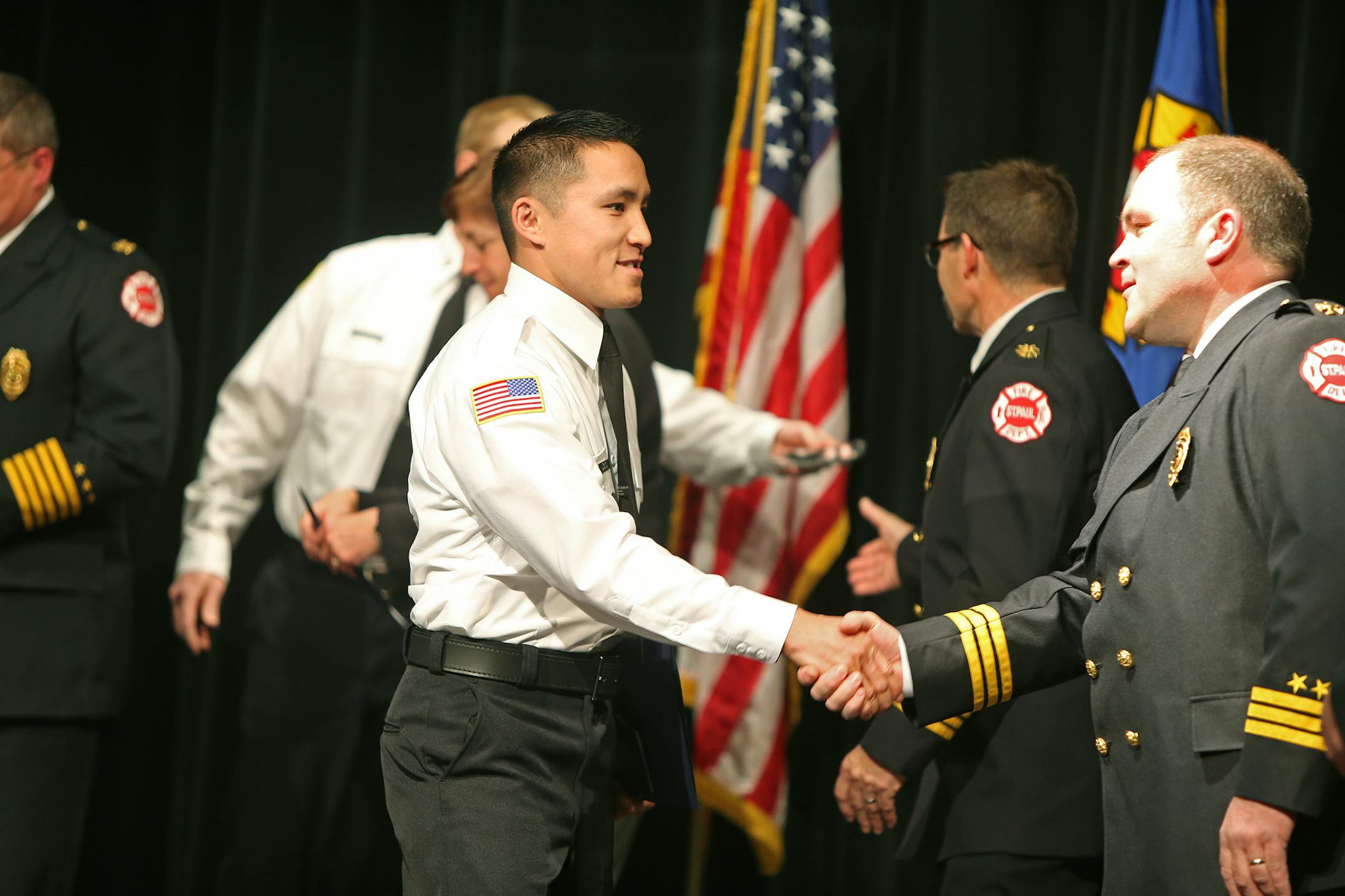 Tou Lo was congratulated by his superiors as he became the first Hmong firefighter at the St. Paul Fire Department's graduation ceremony at the Paul and Sheila Wellstone Center, Friday, January 3, 2014 in St. Paul, MN. (ELIZABETH FLORES/STAR TRIBUNE) ELIZABETH FLORES &#x2022; eflores@startribune.com