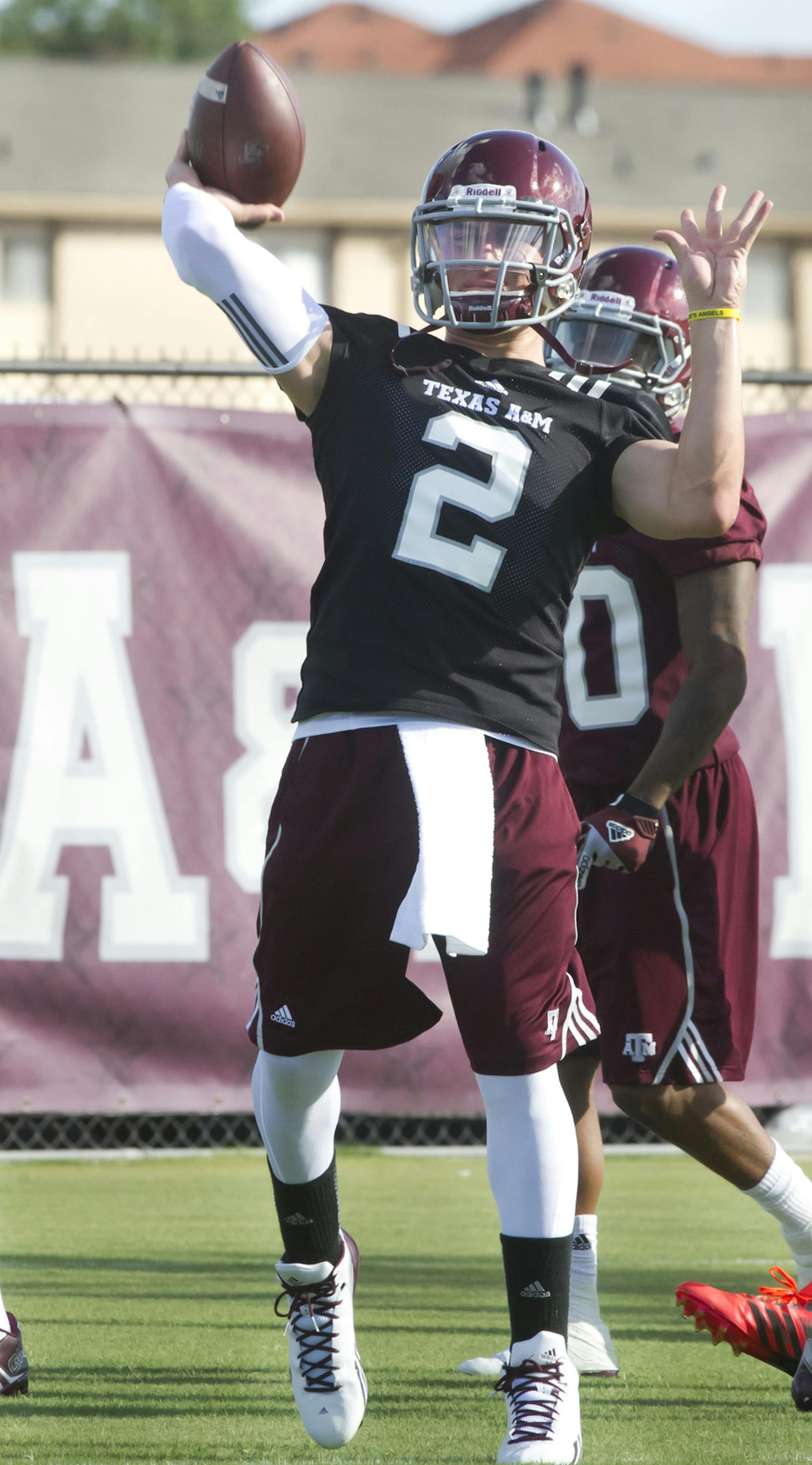 Texas A&M quarterback Johnny Manziel warms up with teammates on the first day of fall practice in College Station, Texas, Monday, Aug. 5, 2013. (AP Photo/Bryan College Station Eagle, Stuart Villanueva) ORG XMIT: MIN2013081217063683