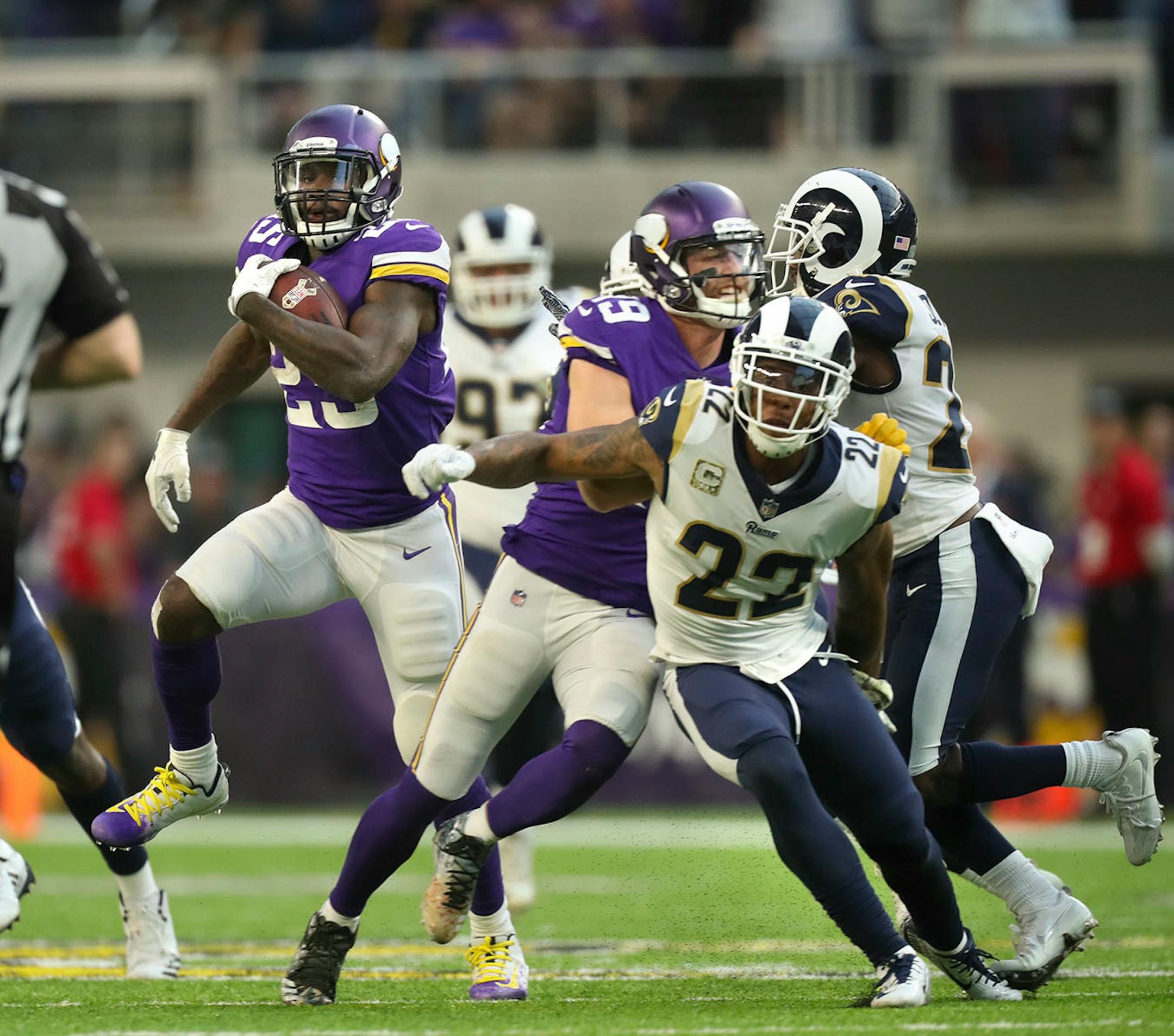 Minnesota Vikings running back Latavius Murray (25) gained 34 yards on a fourth quarter run, but the gain was reduced when wide receiver Adam Thielen (19) was penalized for an illegal block above the waist on Los Angeles Rams cornerback Trumaine Johnson (22).