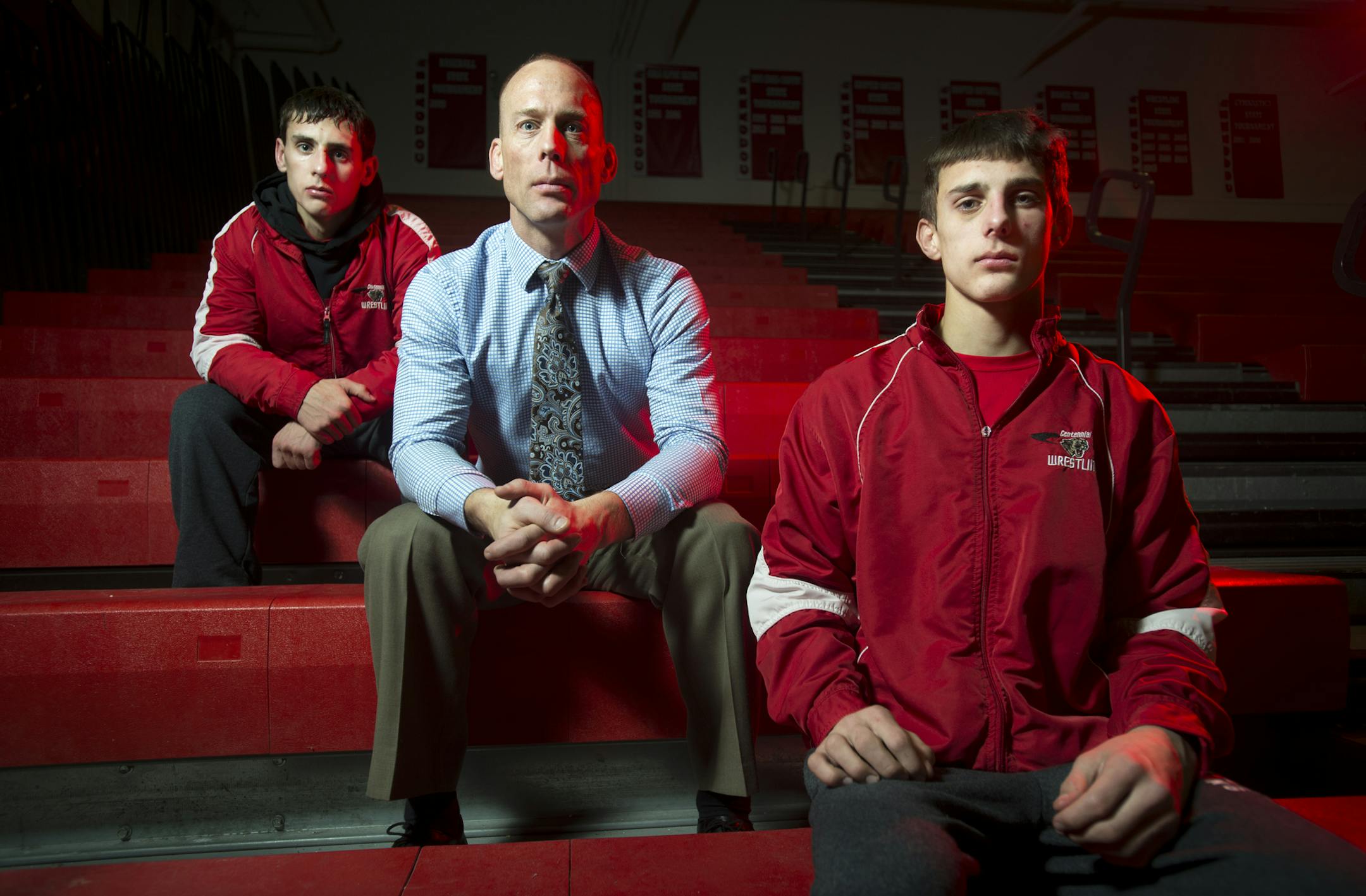 Centennial wrestling coach John Bergeland sat between his sons, senior Jack Bergeland, left, and sophomore Jakob Bergeland, during a meet Friday. (Aaron Lavinsky, Star Tribune)