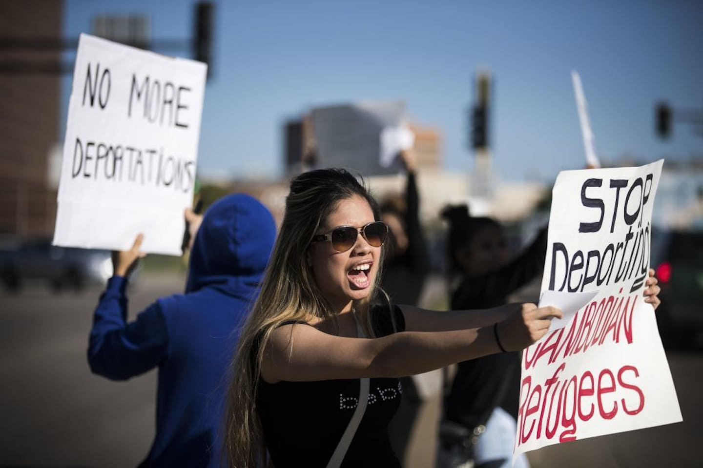 Ketwalee Srisawat of Maplewood chants and holds a sign during a rally to stop deportations of Cambodians. Srisawat's husband Chamrouen Phan was detained by ICE in late August.