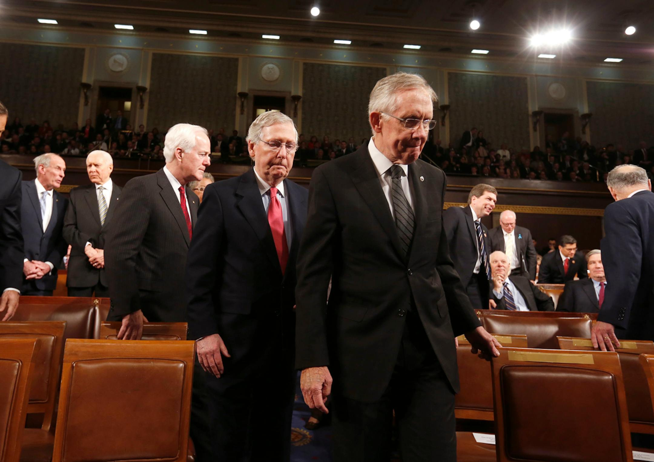 Senate Majority Leader Harry Reid leads Senate Minority Leader Mitch McConnell and Minority Whip John Cornyn to the front of the chamber before President Barack Obama delivers the State of Union address before a joint session of Congress Tuesday, Jan. 28, 2014.
