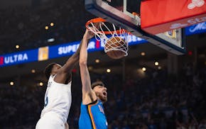Thunder forward Chet Holmgren (7) dunks while Timberwolves guard Anthony Edwards gets to the play late Wednesday night in Oklahoma City.